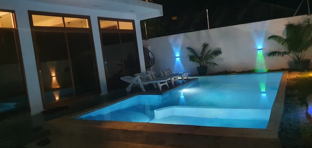 Poolside loungers under coloured lights